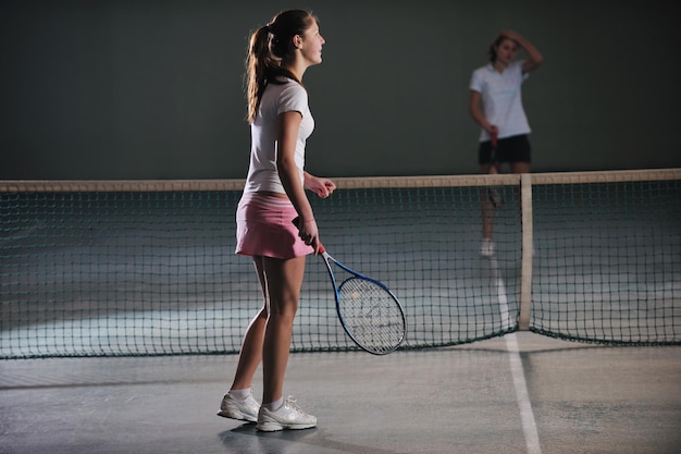 젊은 소녀 들 이 실내 에서 테니스 를 치고 있다