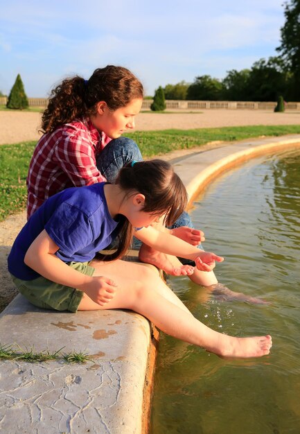 Young girls playing with the fountain