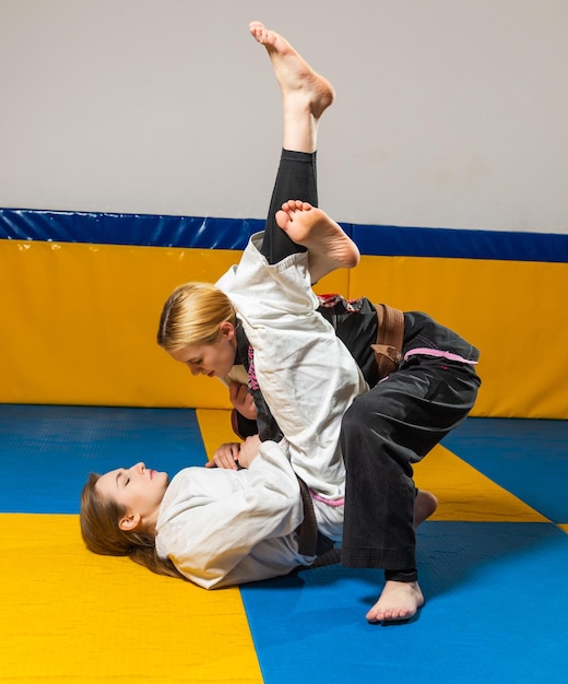 Young girls practice brazilian jiu jitsu in the gym