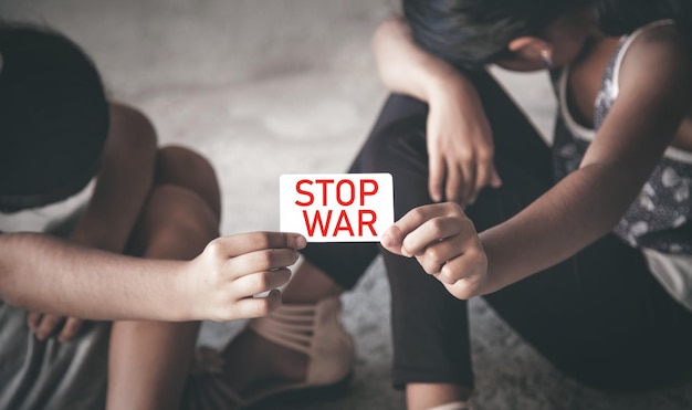 Young girls showing Stop War text on card
