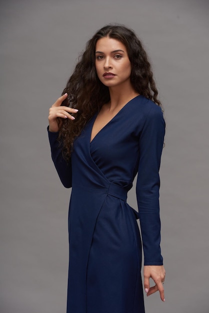 Young glamorous female fashion model in navy blue smart casual dress