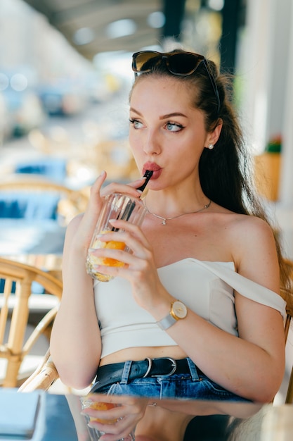 Foto giovane donna glamour bere succo di frutta