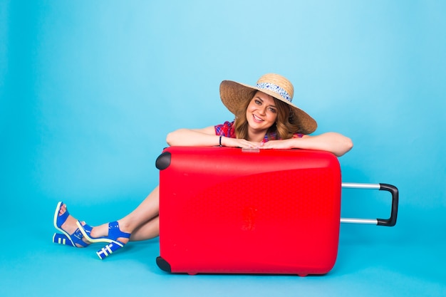 Молодая женщина очарования с красным чемоданом. Концепция путешествий, праздников и людей.