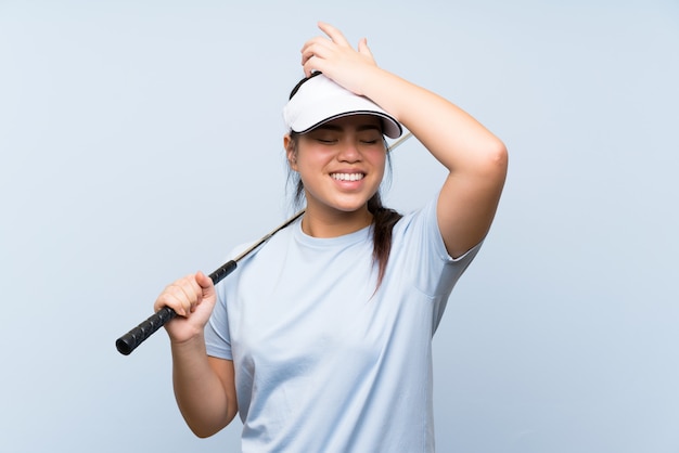 La ragazza asiatica del giovane giocatore di golf sopra fondo blu isolato ha realizzato qualcosa e intendendo la soluzione