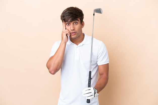 Молодой игрок в гольф, изолированный на фоне охры, думает об идее