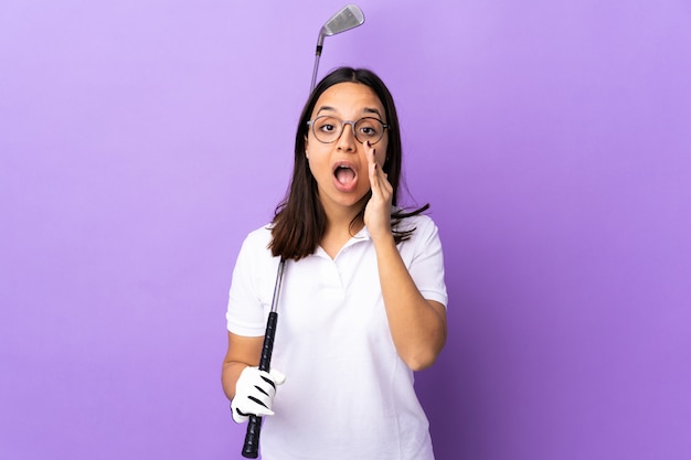 Young golfer woman over colorful wall shouting and announcing something