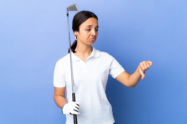 Young golfer woman over colorful wall showing thumb down with negative expression