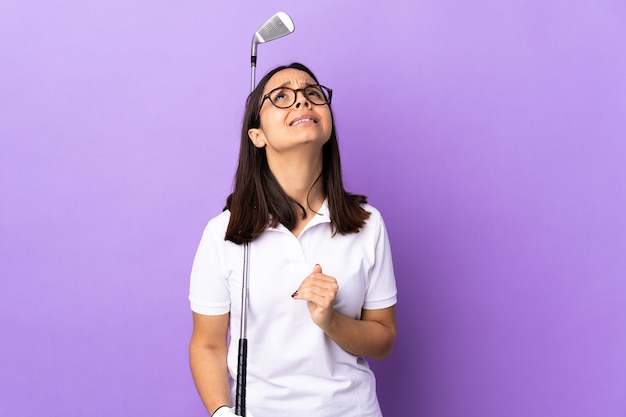 Young golfer woman over isolated colorful background keeps palm together. Person asks for something