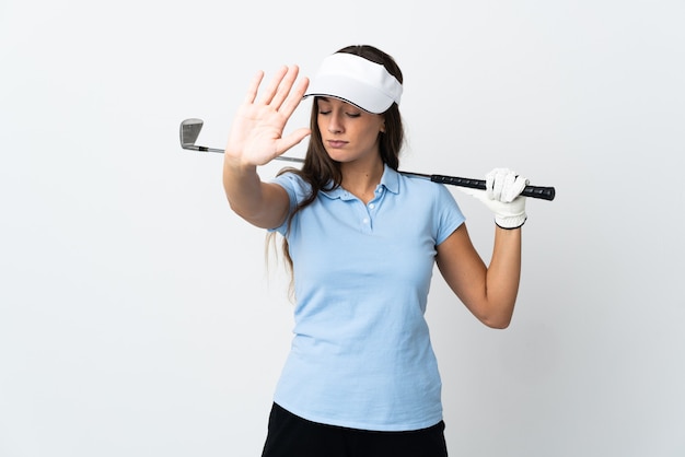 Young golfer woman over isolated white background making stop gesture and disappointed