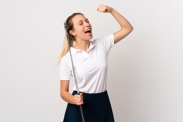 Young golfer woman over isolated white wall celebrating a victory