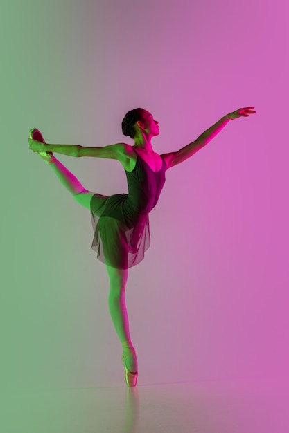 Young and graceful ballet dancer isolated on gradient pinkgreen studio background