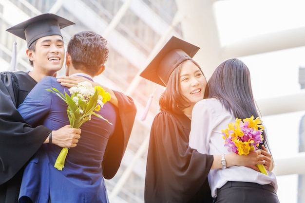 young graduate man and woman with clipping path hugging friend at graduation