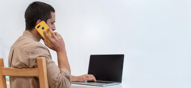 Young graphic designer sitting at his work desk and using a color palette to do an art project