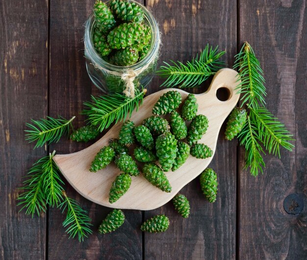 Giovani coni di abete verdi sulla tavola di legno. per fare l'infusione medicinale.