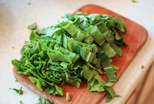 Young green sorrel sliced for borscht and salad lies on a cutting board, rustic style