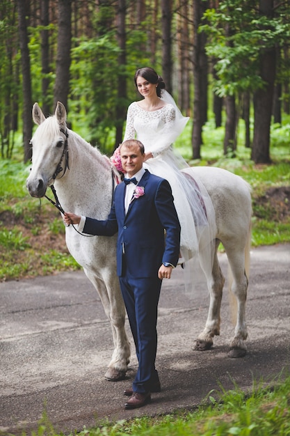 若い新郎と新婦の公園で馬