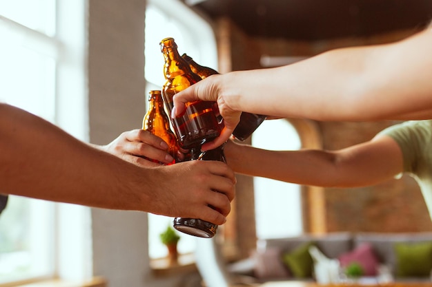 Young group of friends drinking beer, having fun, laughting and celebrating together.