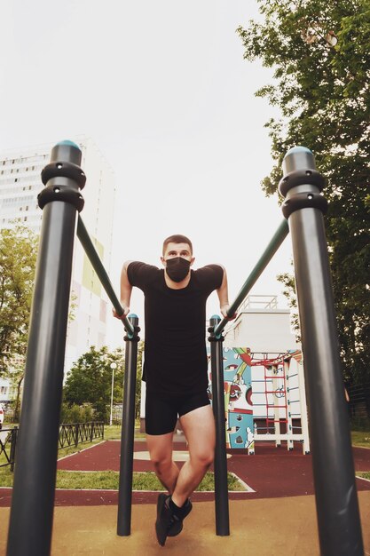 Young guy, an athlete engaged on uneven bars