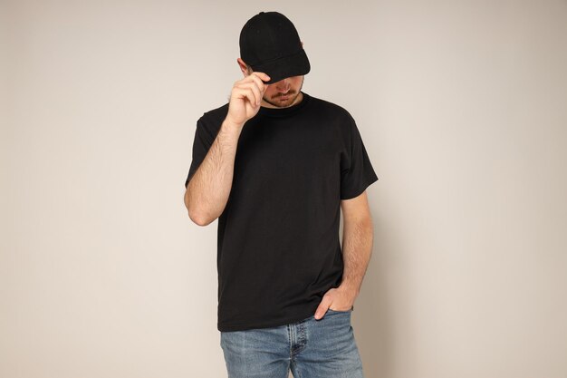 Photo a young guy in a black tshirt and cap