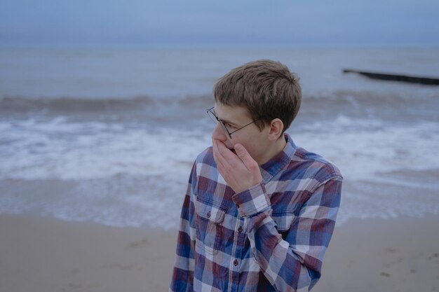 Young guy covers his mouth while yawning