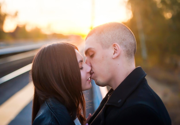 Young guy and a girl kiss in the evening at sunset Closeup profile