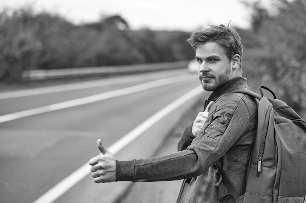 Young guy hitchhiking autostop