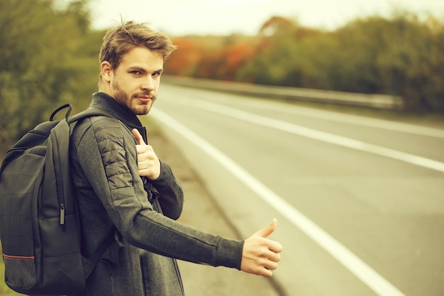 Young guy hitchhiking autostop