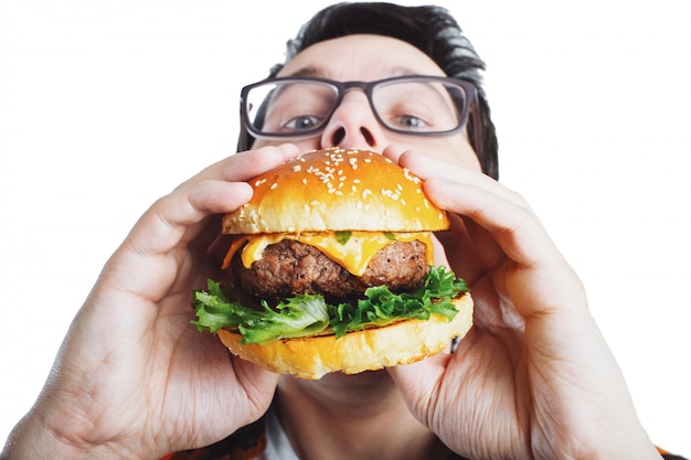 Un giovane ragazzo in possesso di un hamburger fresco.