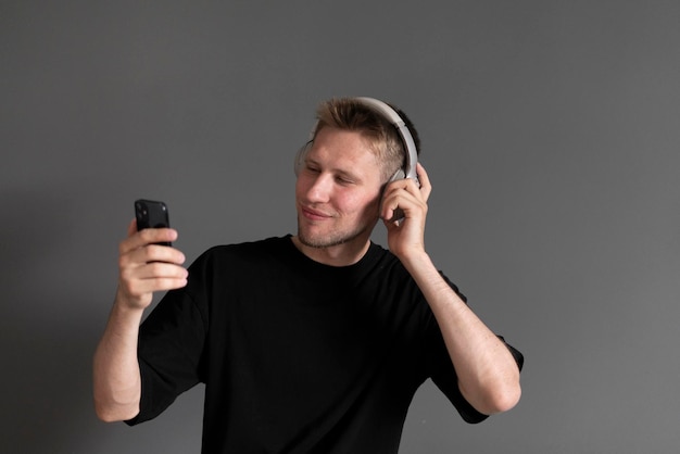 Young guy listening to music in wireless headphones at home