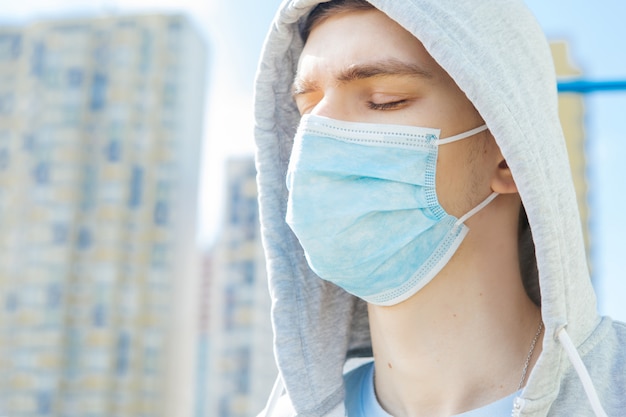 Foto giovane ragazzo in una maschera medica fuori