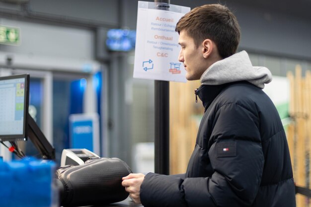 Photo a young guy pays for purchases in the store