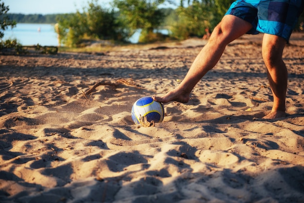 Young guy playing volleyball on the beach