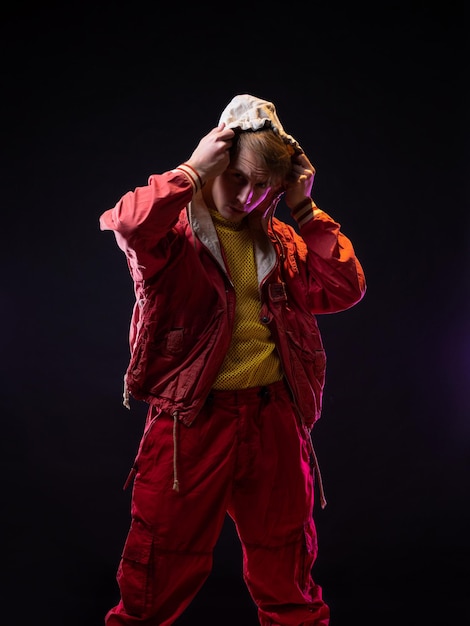 A young guy in a red youth jacket with a hood stylish outfit modern style photo on black