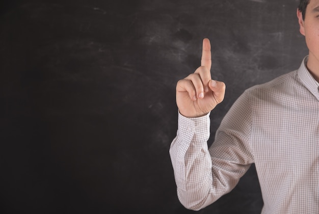 Young guy shows index finger up .