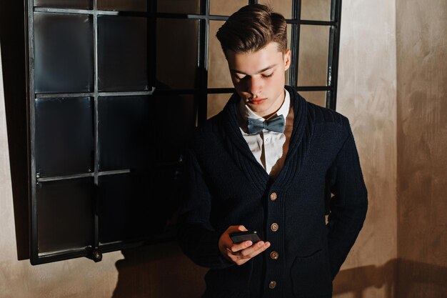 A young guy in a suit with a tie looks into a smartphone.\
solves the case. phoned. calls on business.