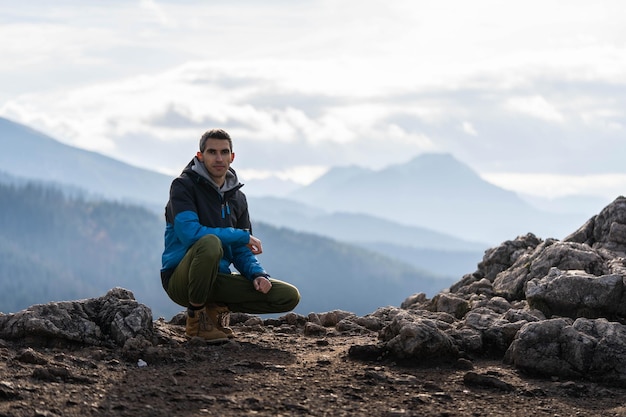 Young guy at the top of the mountain. Concept: freedom, freshness, silence, happiness, incredible wildlife