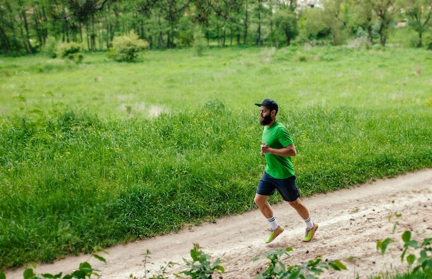 Young guy training outdoors Male runner jogging at the park Healthy lifestyle concept