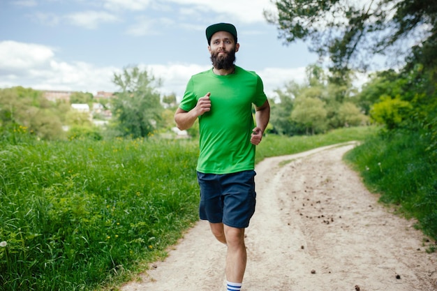 屋外でトレーニングする若い男公園でジョギングする男性ランナー健康的なライフスタイルのコンセプト