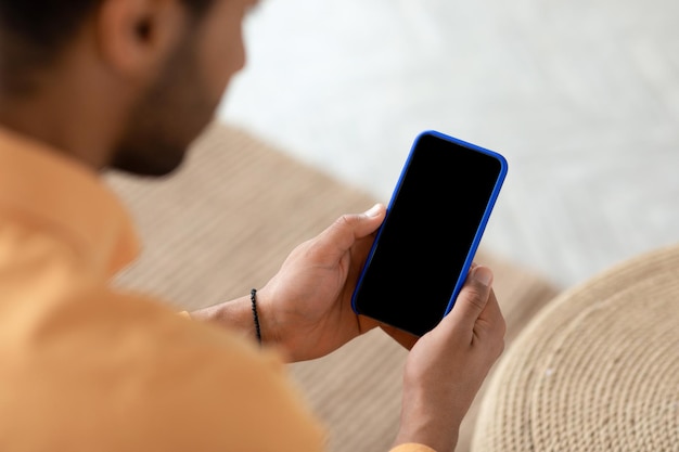 Young guy using cell with empty screen mockup