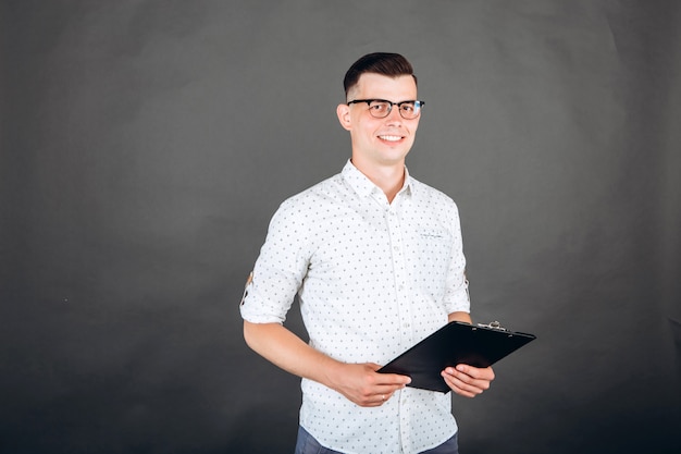 A young guy in a white shirt on dark.