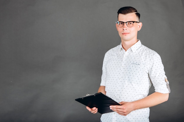 A young guy in a white shirt on dark.