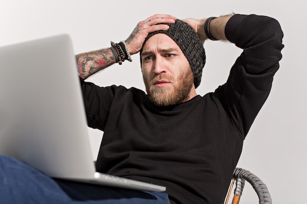 Giovane ragazzo con la barba con un computer portatile