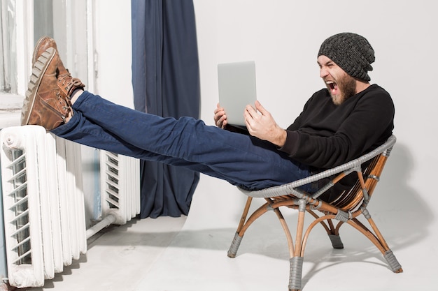 Giovane ragazzo con la barba con un computer portatile