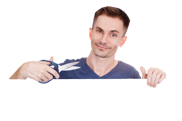 Young guy with scissors in hand on a white background. Copy space.