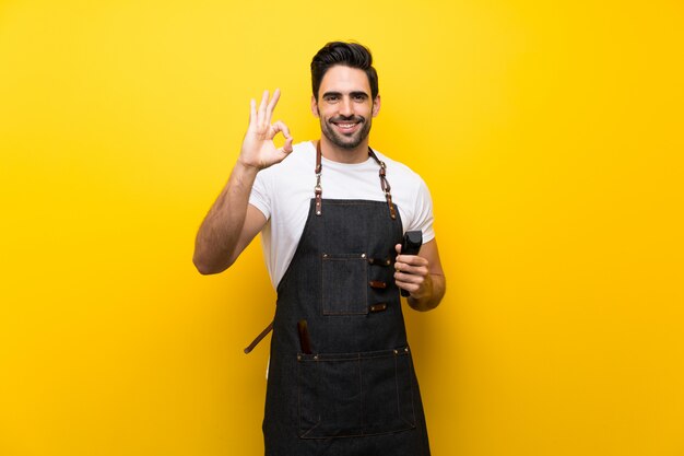 Young hairdresser man showing ok sign with fingers