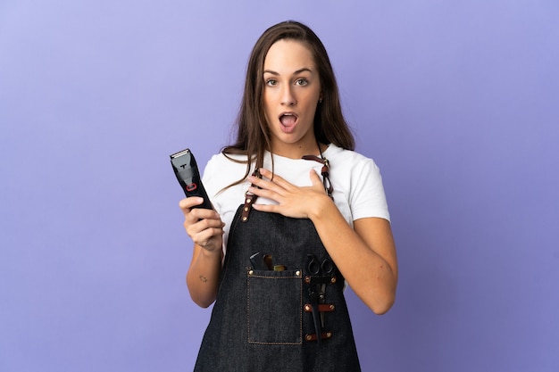 Young hairdresser woman over isolated background surprised and shocked while looking right