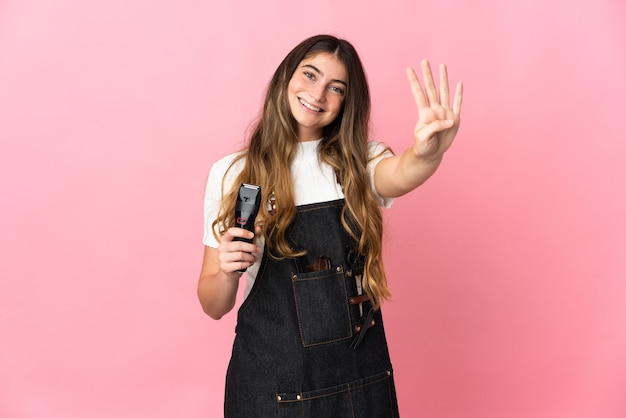 Young hairdresser woman isolated on pink wall happy and counting four with fingers