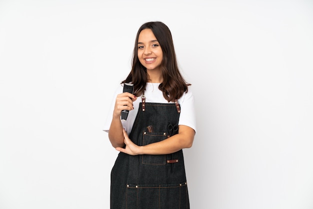 Young hairdresser woman on white looking up while smiling