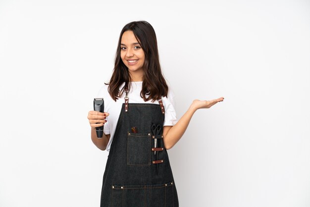 Young hairdresser woman on white wall presenting an idea while looking smiling towards