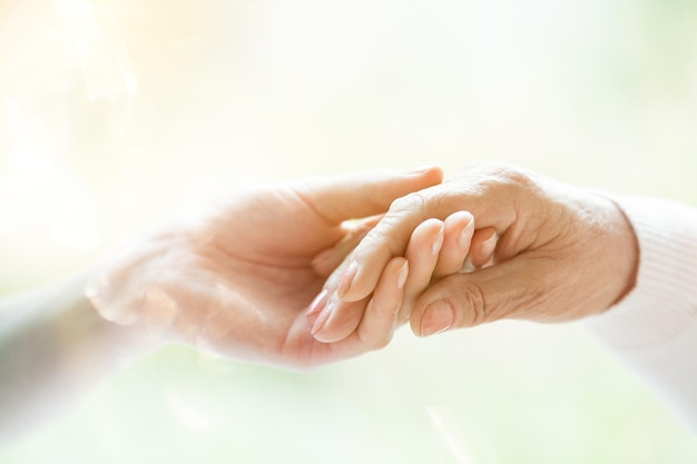 Photo young hand holding elderly hand